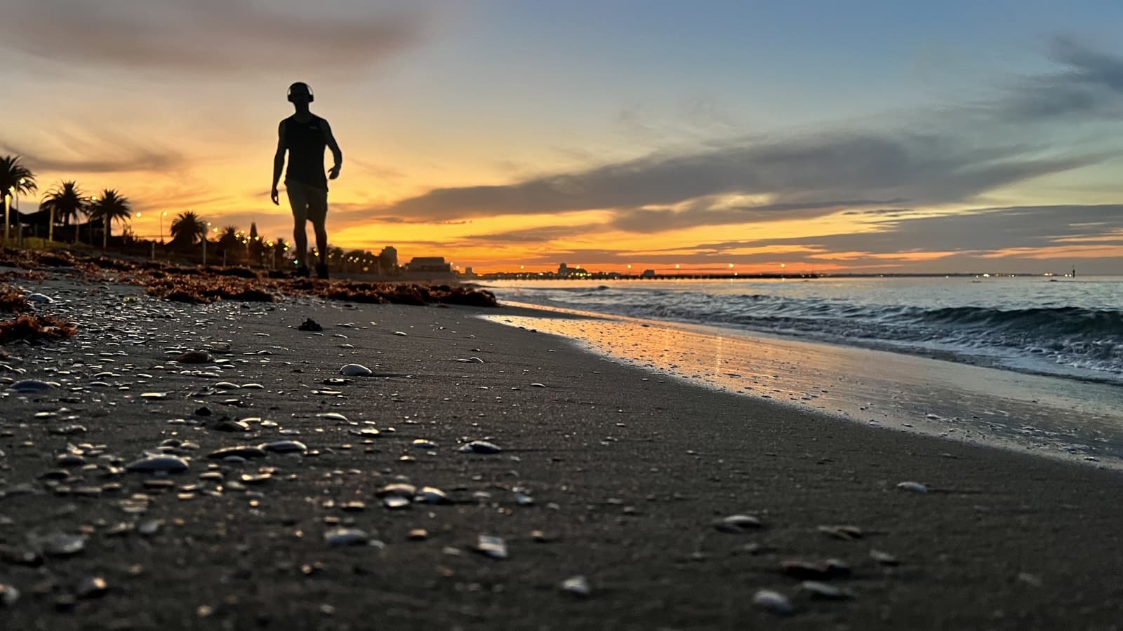 Andy Jacobs walking along Port Melbourne beach at sunrise