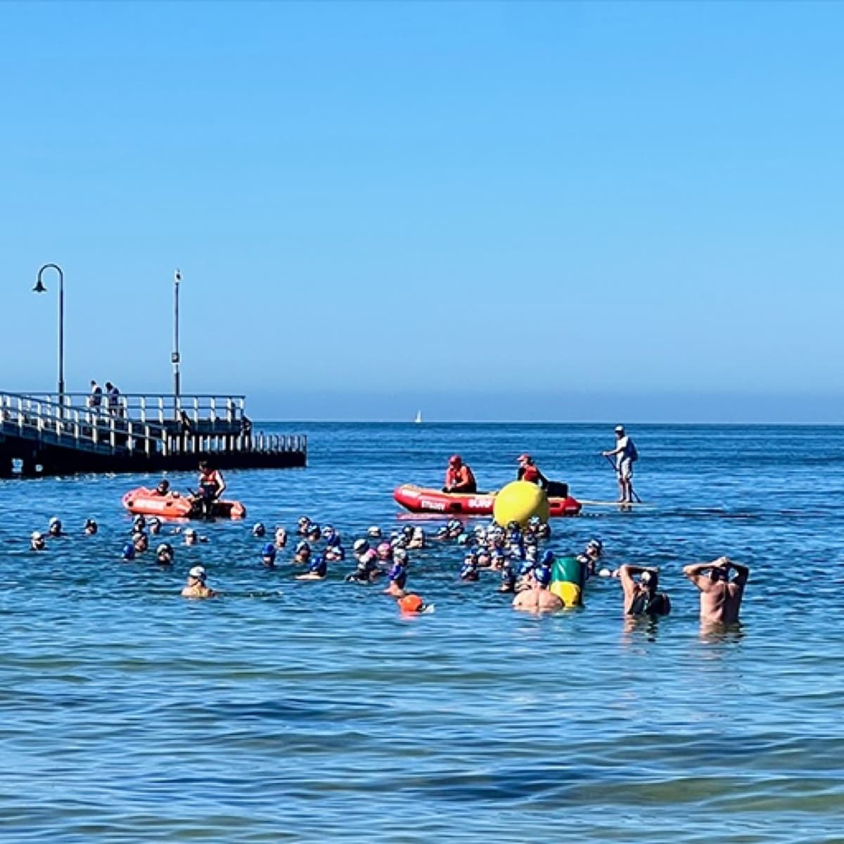 Open-water swimmers gathering beside South Melbourne pier